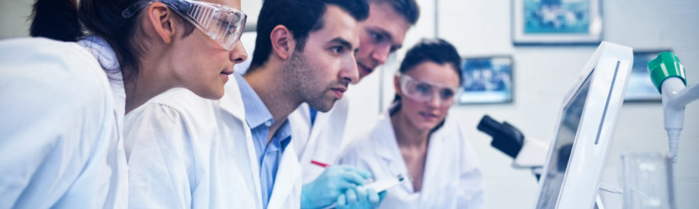 Side view of serious researchers looking at computer screen in the laboratory