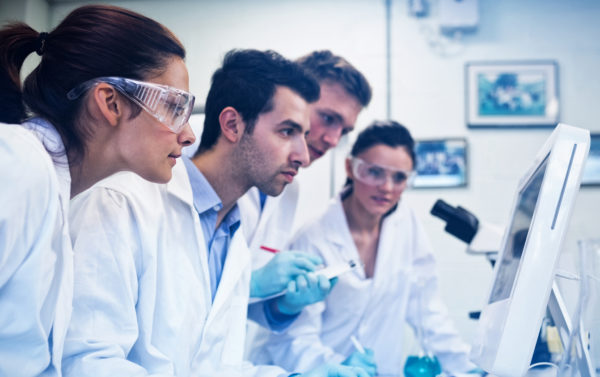 Side view of serious researchers looking at computer screen in t