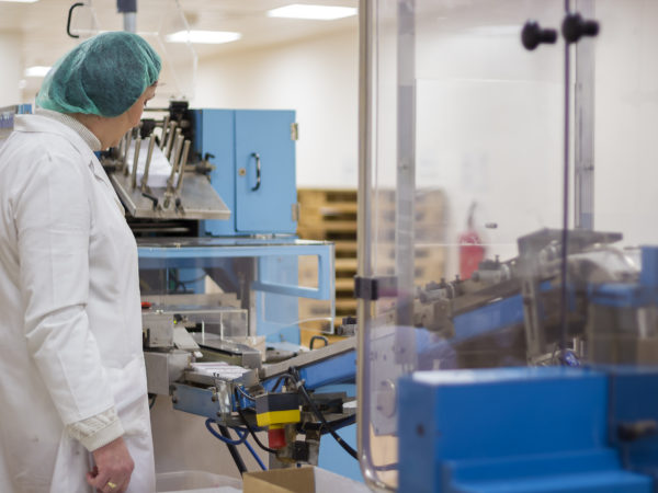 Pharmaceutical Factory Worker . Pharmaceutical female worker controlling the medical pill packaging line.